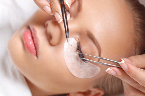 Woman having eyelash extensions applied