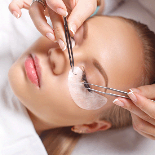 Woman having eyelash extensions applied
